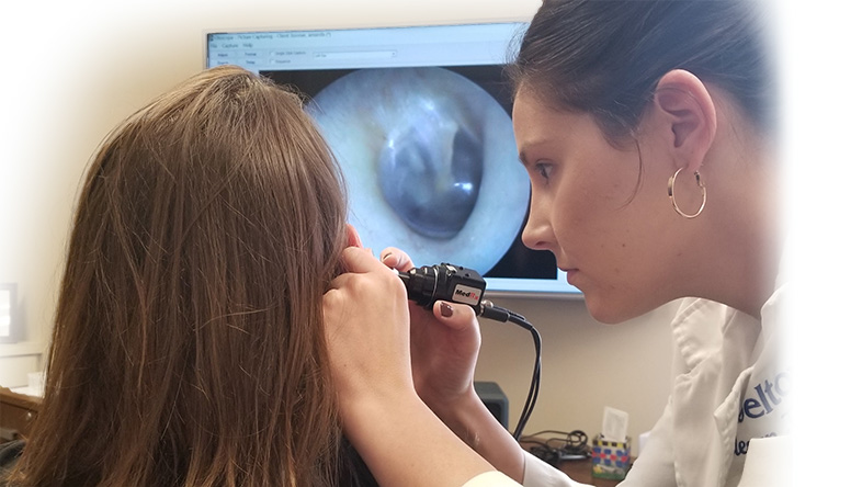 A Beltone Hearing Care Professional using a video otoscope in a patient's ear