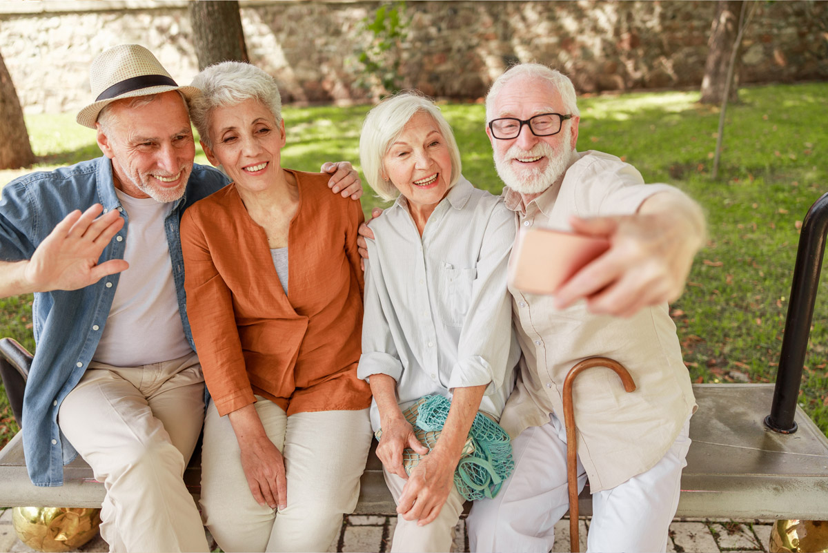 Two senior couples wearing Beltone Hearing Aids take a group selfie