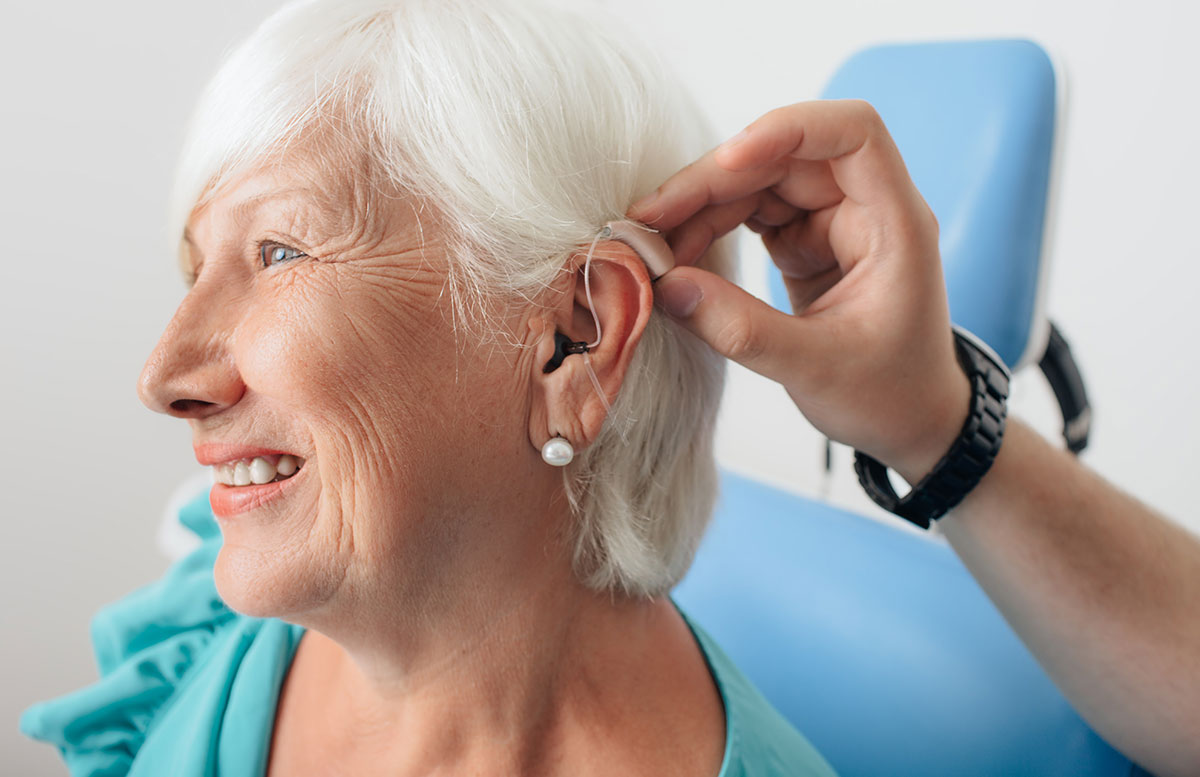 A woman getting a hearing aid fit to her ear at a Beltone Hearing Aid Center