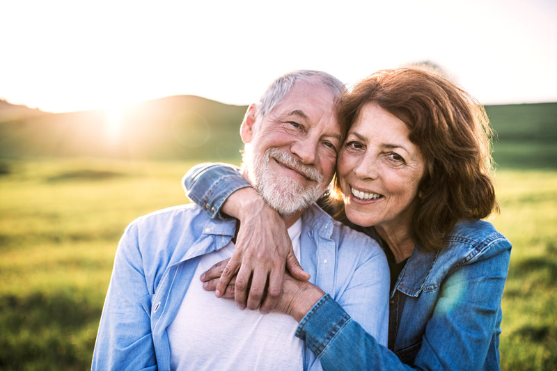 Senior couple smiling in grass field