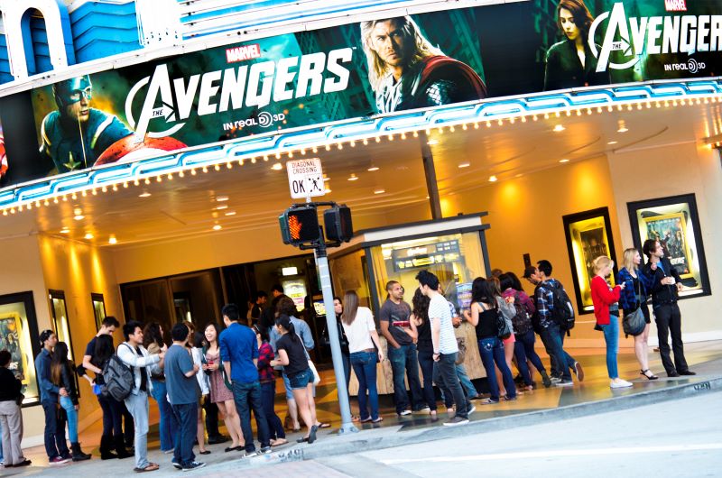 young people stand outside theatre to watch The Avengers