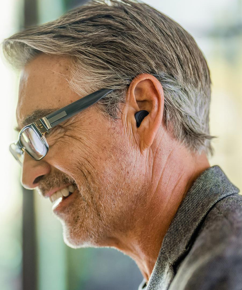 side portrait of a man wearing Beltone Imagine Custom Rechargeable hearing aids