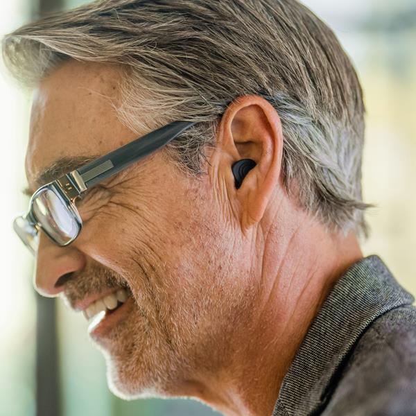 a person smiling wearing Beltone custom rechargeable hearing aids