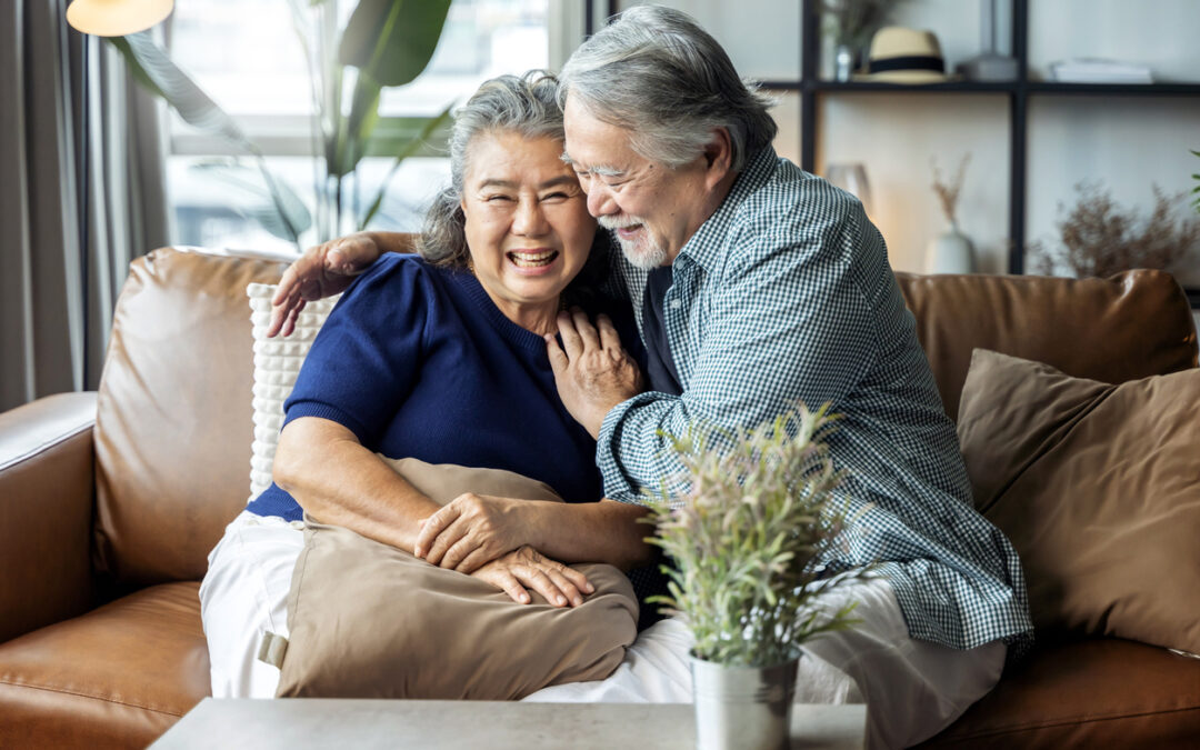 Healthy aging month celebrated by a happy elderly couple sitting on the couch