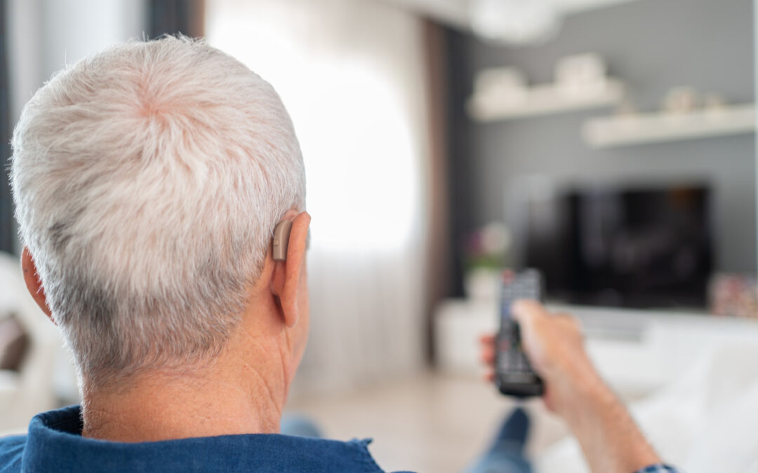 Man watching TV with hearing aids.